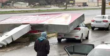 Fırtınanın devirdiği tabela otomobilin üzerine düştü